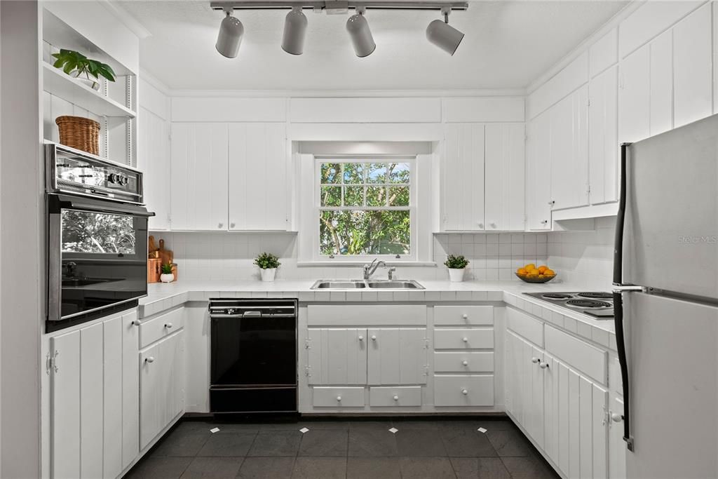 Kitchen with white wood cabinets and vintage appliances.