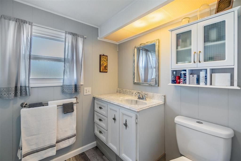 Main bathroom has step-in shower, high toilet, and updated vanity.