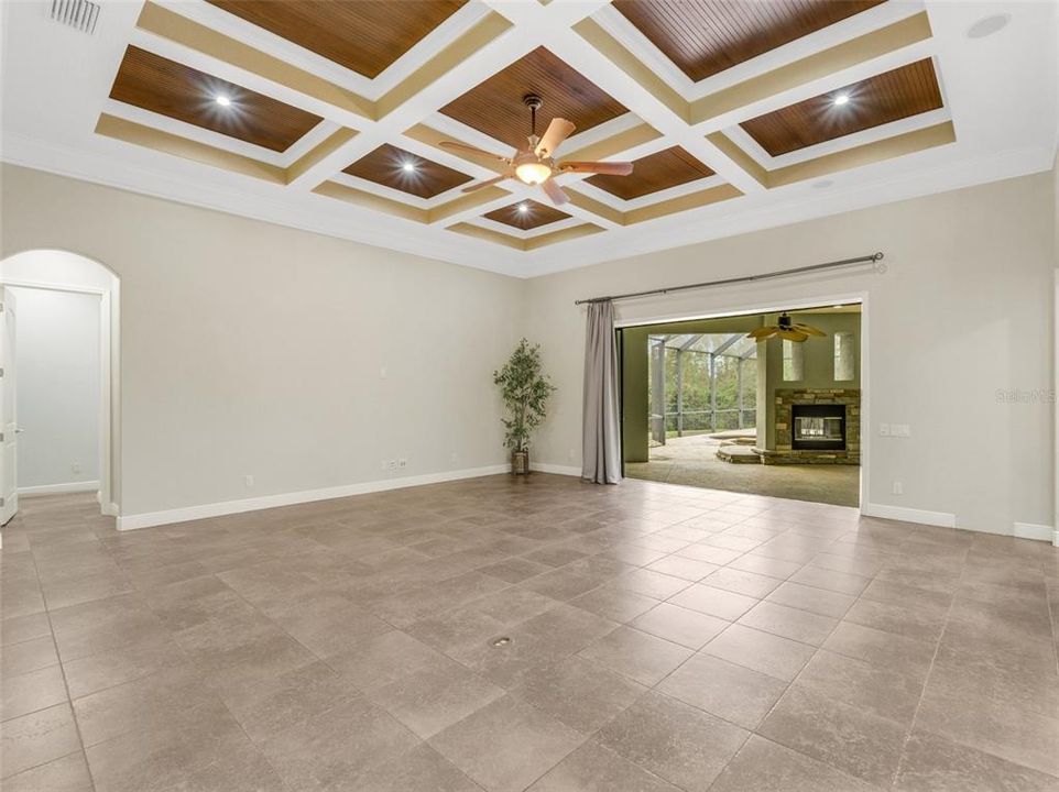 The family/great room features a stunning set of glass sliders that completely pocket for seamless entertaining. Soaring ceilings, crown molding and a beautiful coffered ceiling are a few of the homes many custom features.