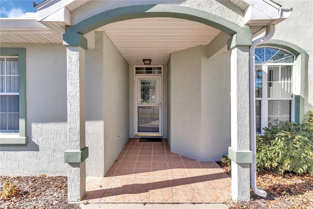 Front entry way with tile detail.  Very inviting!  Storm door to allow light to flow into home.