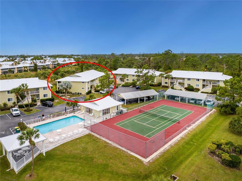 Aerial of tennis/pickleball court, pool and clubhouse