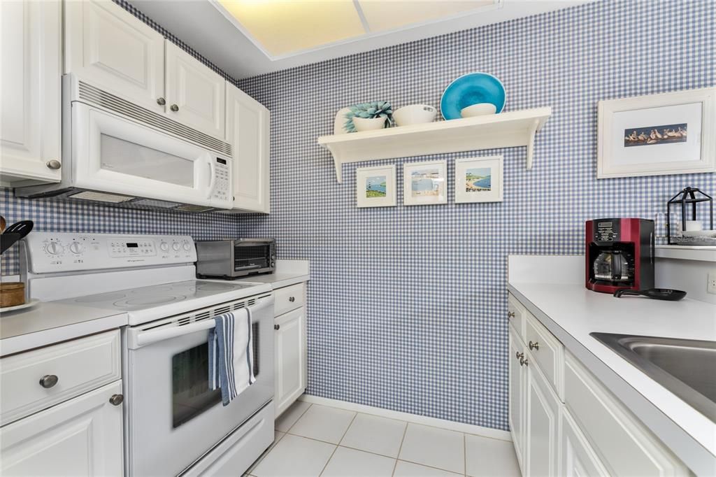 Galley kitchen has updated cabinetry and countertops.