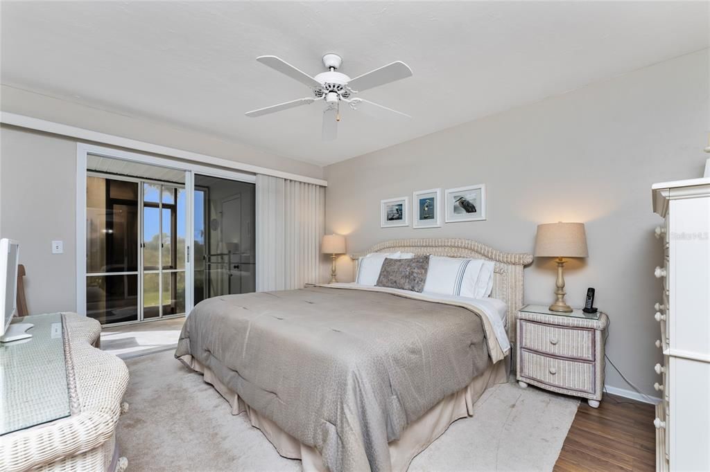 Master bedroom has both carpeted and wood flooring, ceiling fan and walk in closet.