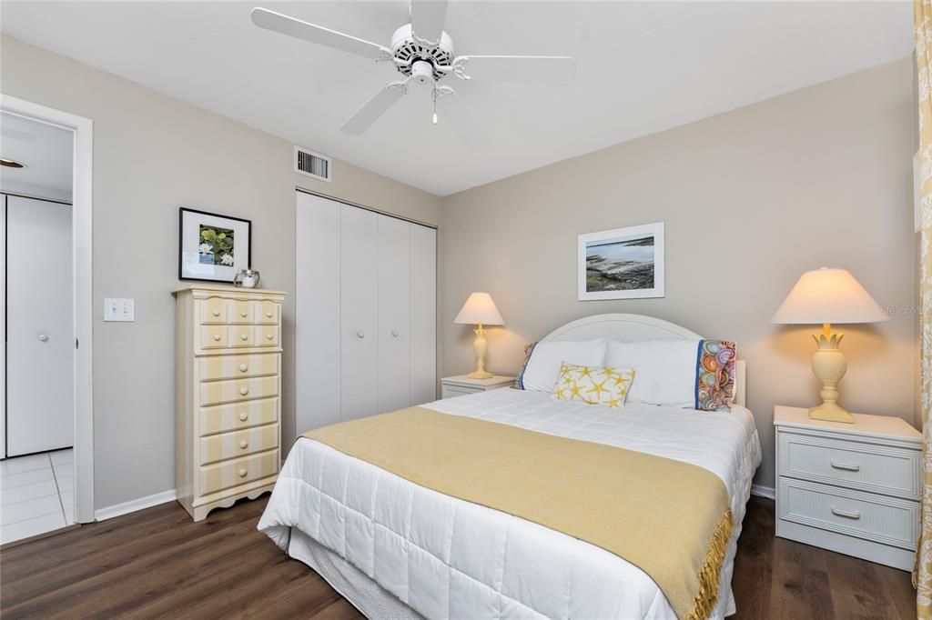 Guest bedroom has Luxury vinyl plank flooring, wall closet and ceiling fan.