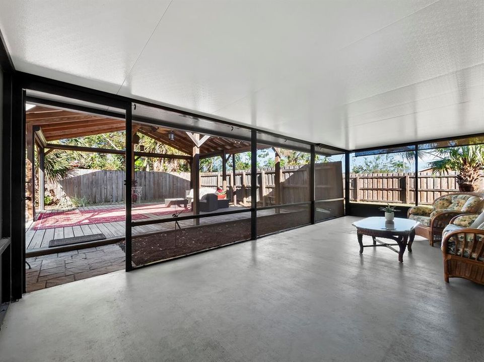 The screened in porch off both the primary bedroom and the living room opens up to the large, private backyard and that amazing 400sf pergola.