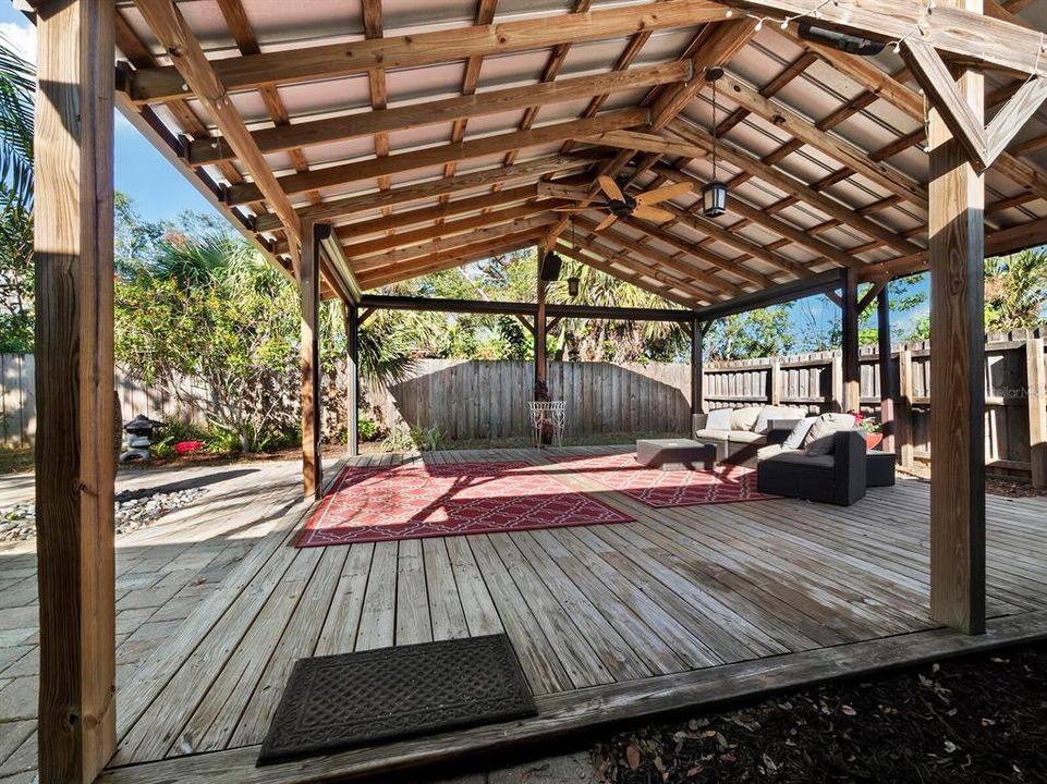 An outdoor paradise featuring a 400sf metal roofed pergola with lights and a fan and retractable shades. Perfect for el fresco dining or watching the game!