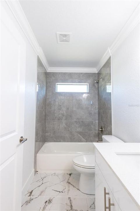 Nice 2nd bath with tiled floors and neutral colors.