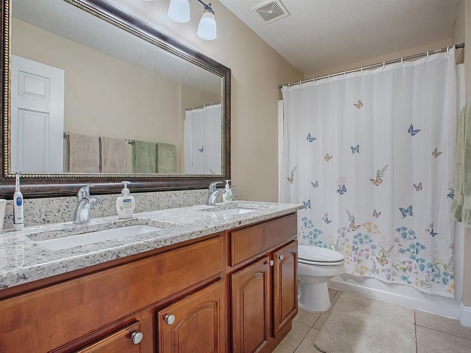 Guest bathroom with dual sinks and granite countertops