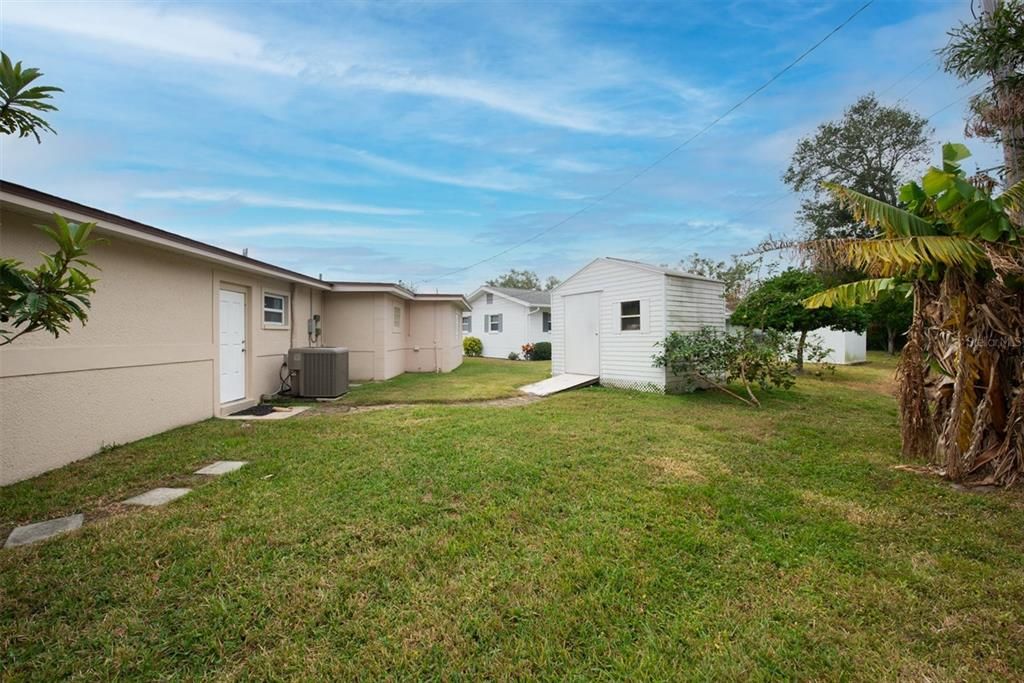 Back yard view with custom storge shed for ample storage!