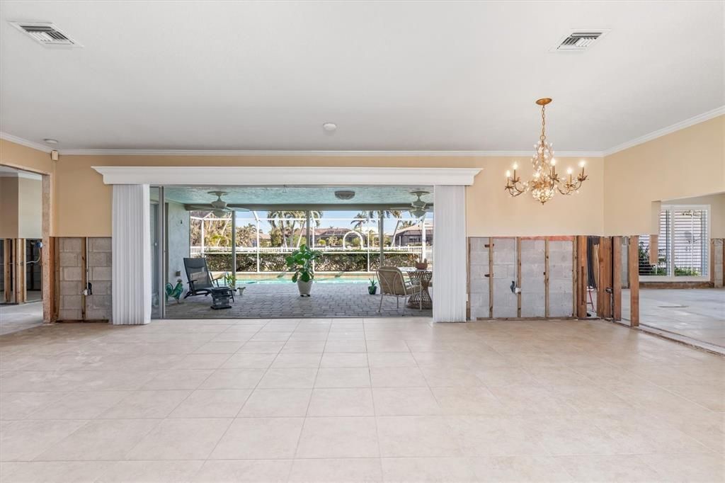 Enter at front door looking through Great room to lanai and pool.  Living area on left and center.  Dining area to right side. Crown molding throughout home.