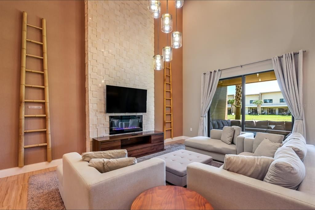 Family room with Fireplace, TV and stone wall that goes all the way to the celing.