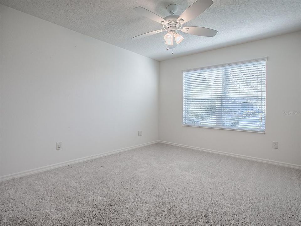 FRONT GUEST ROOM WITH CARPET AND CEILING FAN.  LARGE WINDOW FOR LOTS OF LIGHT.