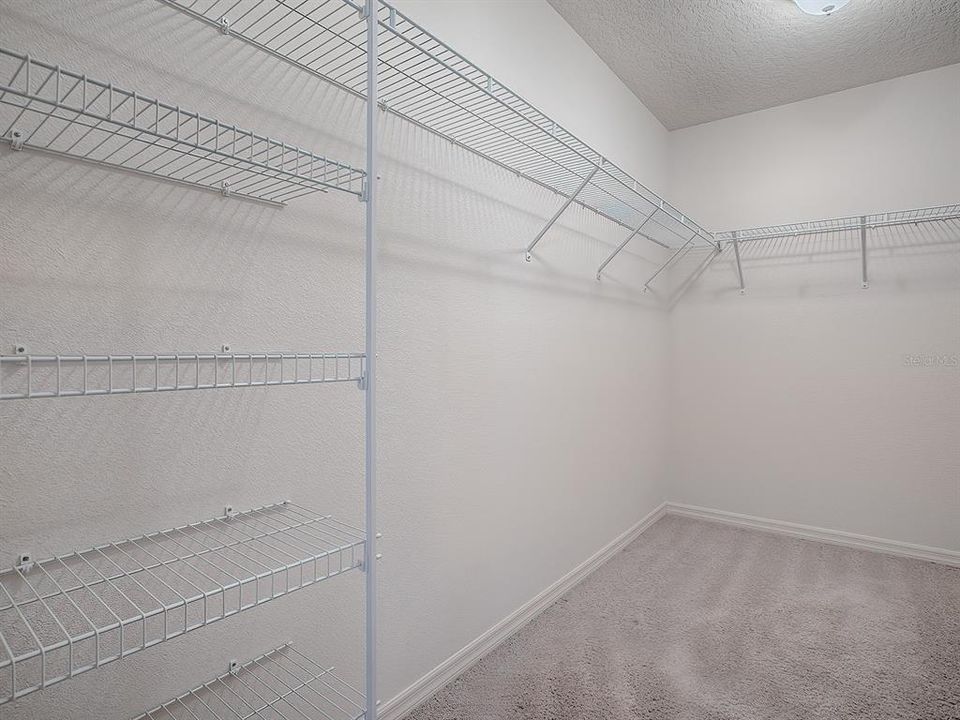 WALK-IN CLOSET WITH EXTRA RACKS.