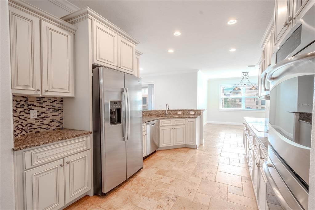 The cabinets, in a soft oatmeal shade, showcase a timeless classic design with intricate layering and thoughtful attention to detail, adding warmth and sophistication to the space.