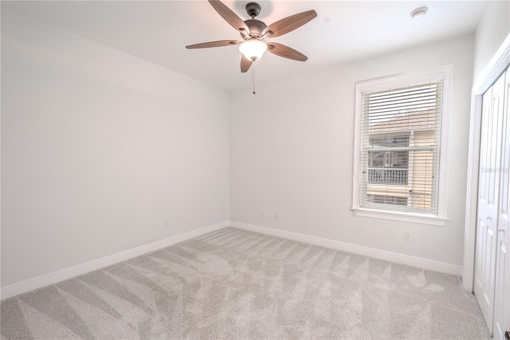 The 2nd bedroom features new, neutral tone carpet and walls, a built in closet, ceiling fan and window blinds.