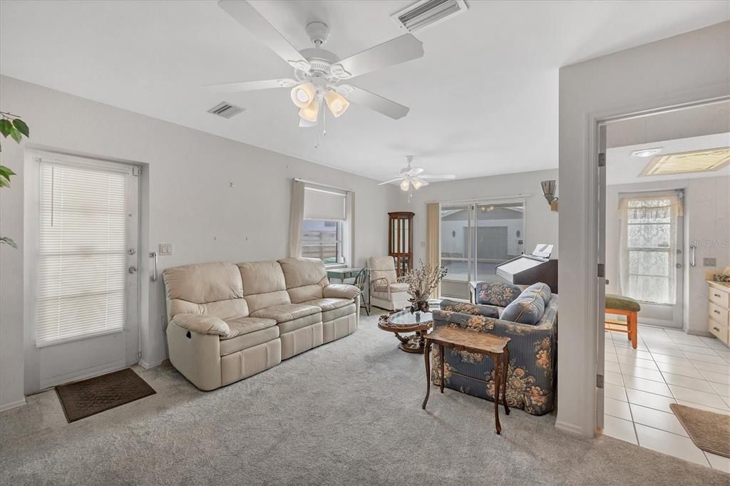 Living room with sliders and side door facing the backyard.  Pool bath and door go out to the back screened patio