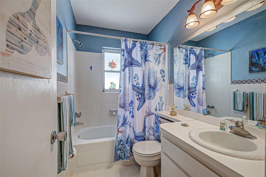 The bathroom is cheerfully painted and has a large counter top.