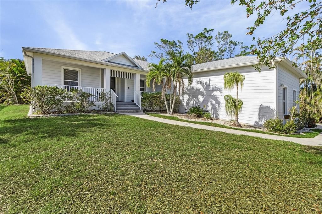 Single story home featuring a porch and a front lawn