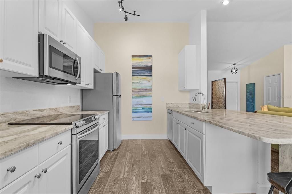 Kitchen featuring kitchen peninsula, a breakfast bar, stainless steel appliances, and white cabinets