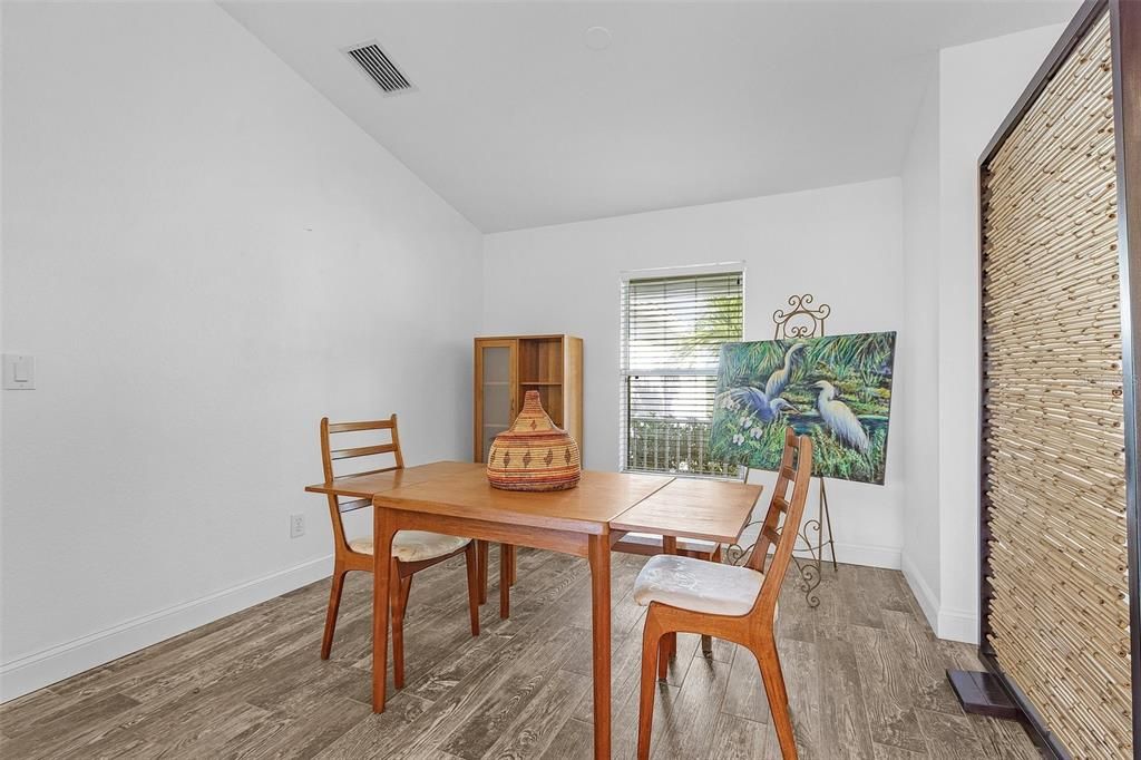 Dining space with vaulted ceiling and hardwood / wood-style flooring