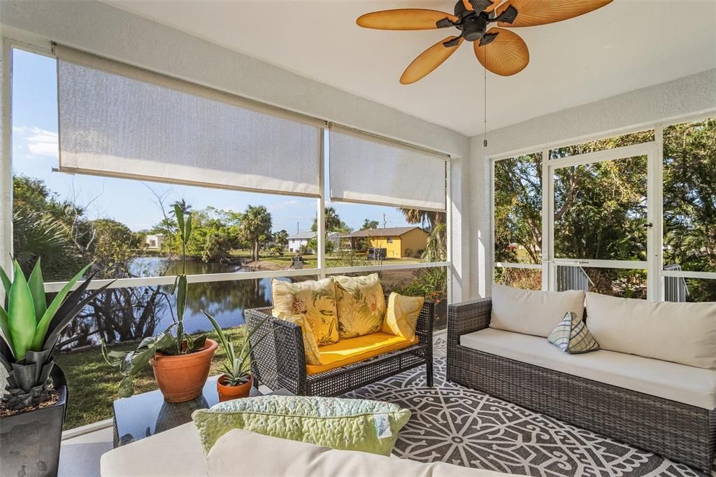 Sunroom / solarium featuring ceiling fan and a water view