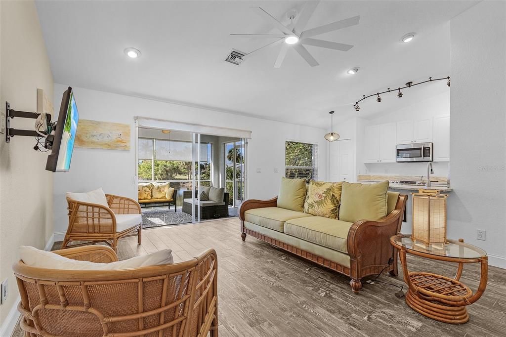 Living room with hardwood / wood-style floors, a wealth of natural light, and ceiling fan