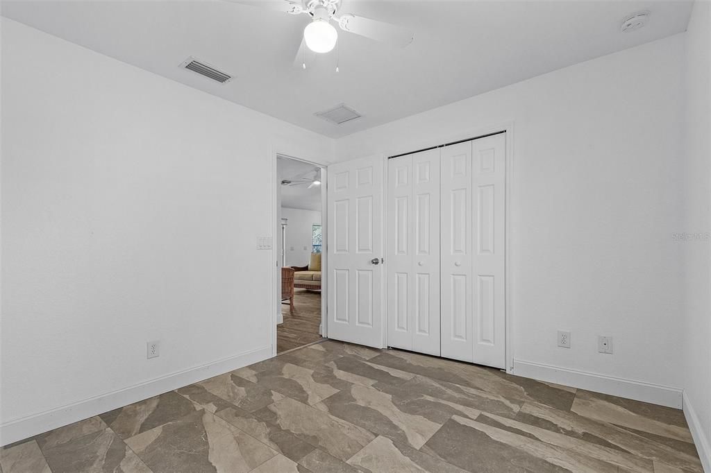 Unfurnished bedroom with ceiling fan and a closet