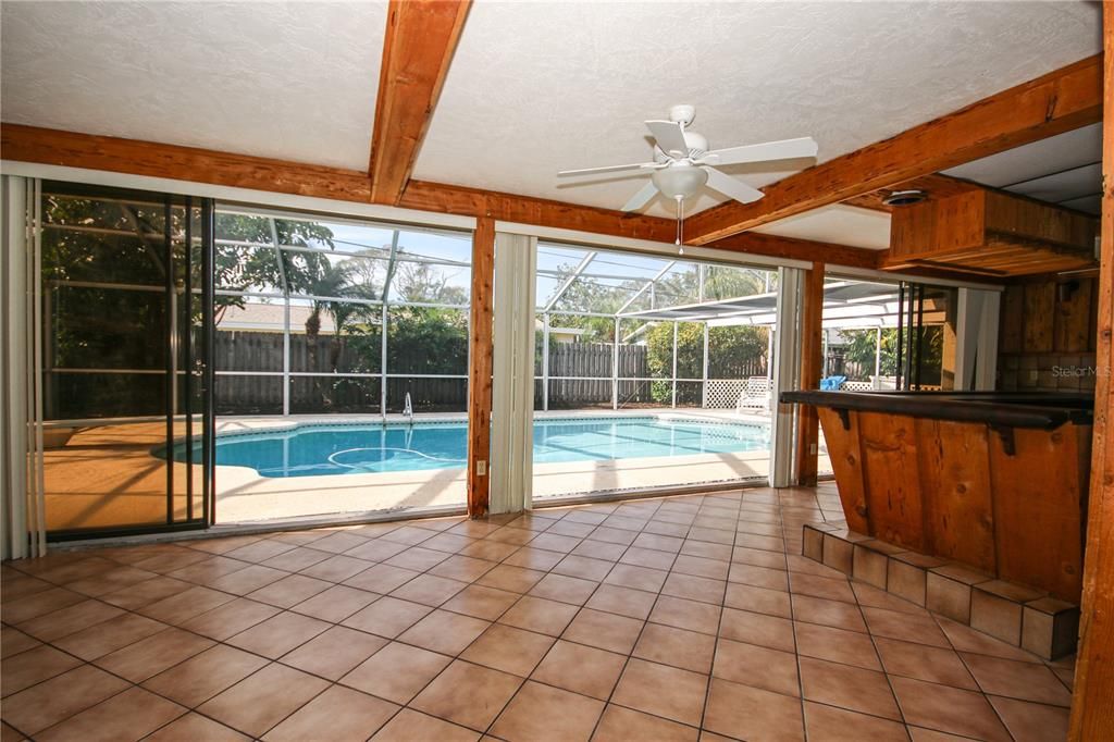 View from Living Room to Pool showing Sunroom Custom Bar