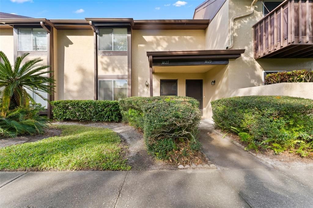 Tropical manicured landscaping lead to the front door of your new home