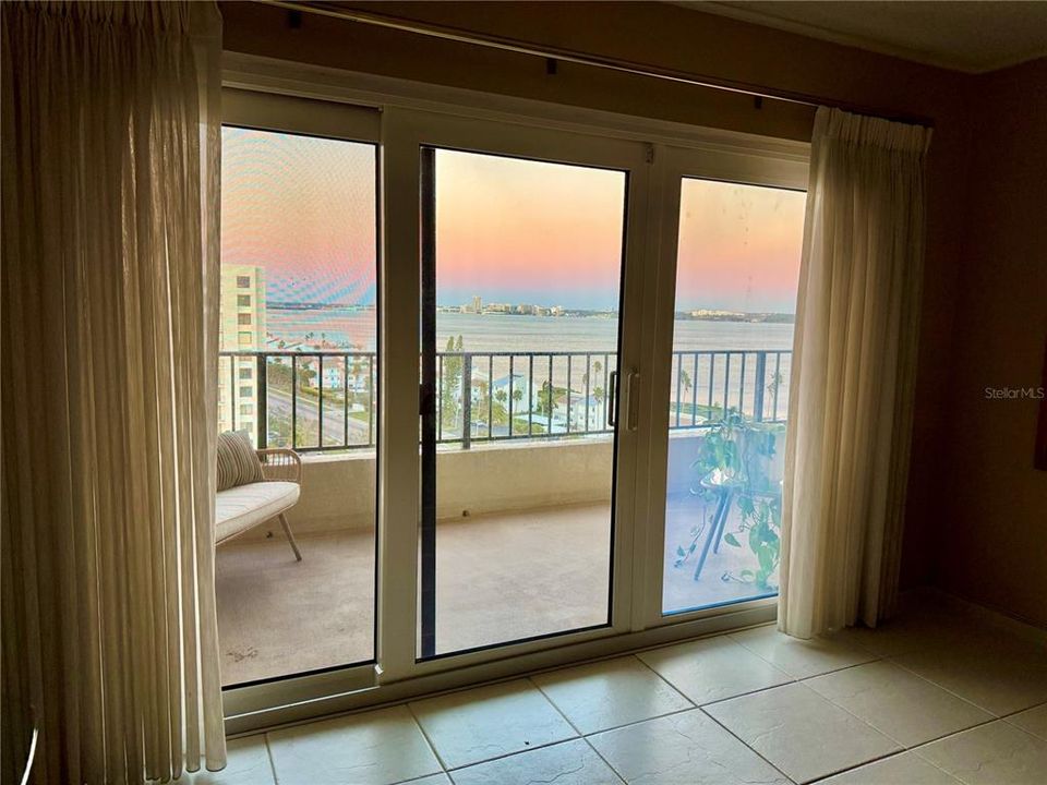 Primary bedroom suite with water views through sliding doors that open to balcony.