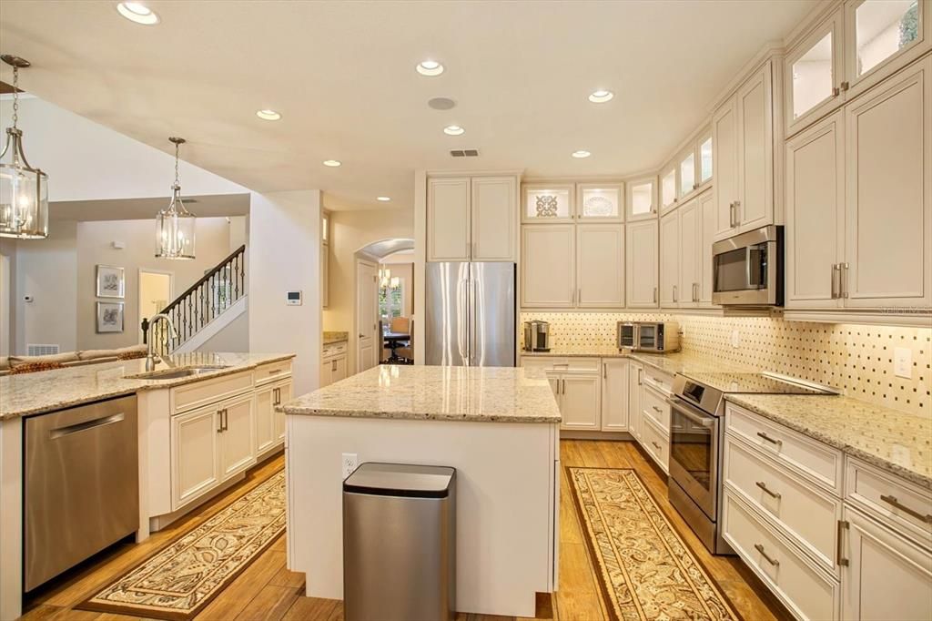 Custom kitchen w/ new Bosch appliances. View of the dry bar w/ custom cabinets and into the dinning room