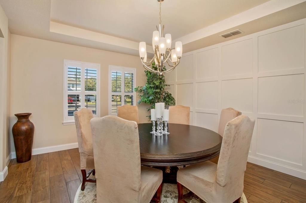 Dinning room w/ trey ceiling and custom wood paneling.