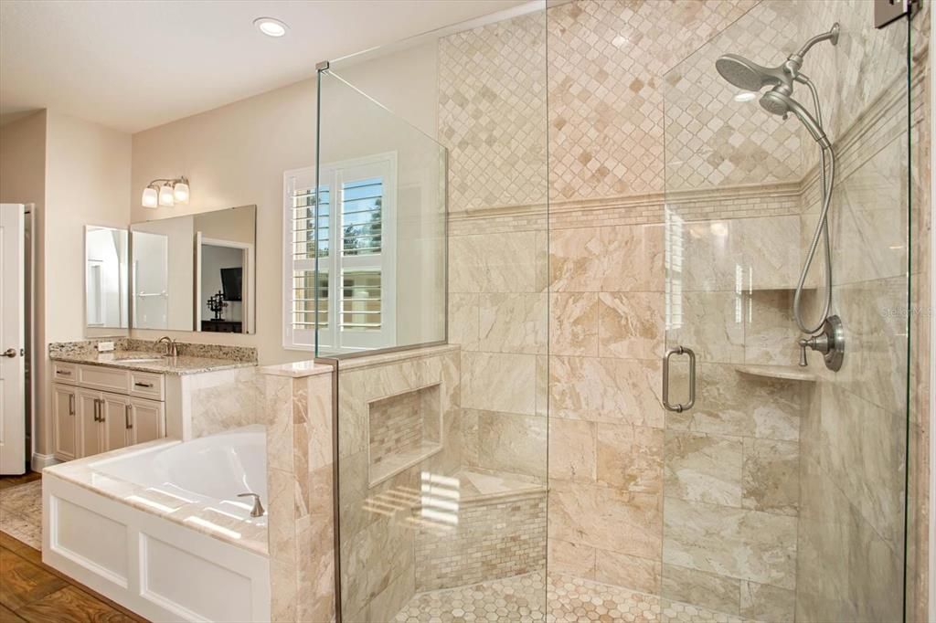 Primary bath shower w/frameless glass doors and Turkish tile surrounding the shower and tub.