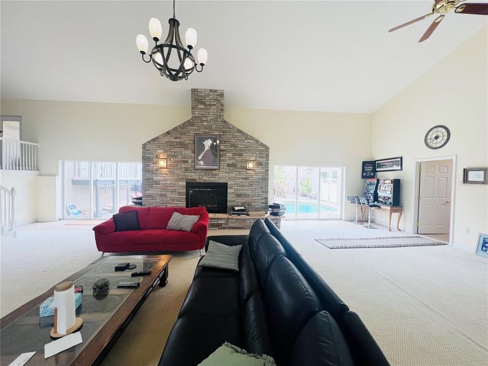 VIEW OF FIRE PLACE AND SLIDERS THAT LEAD TO COURT YARD BATHROOM TO RIGHT WET BAR TO RIGHT