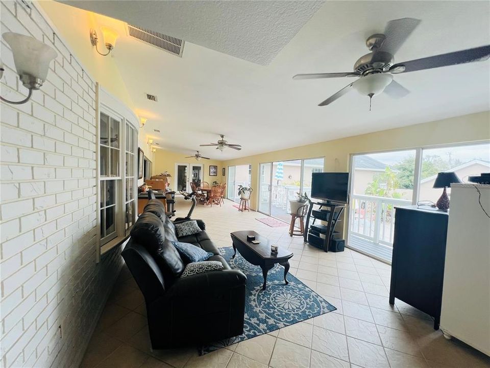 VIEW FROM OTHER SIDE OF LIVING AND DINING AREA WITH WET BAR AND SLIDING DOORS OPEN TO INSIDE AND OUTSIDE