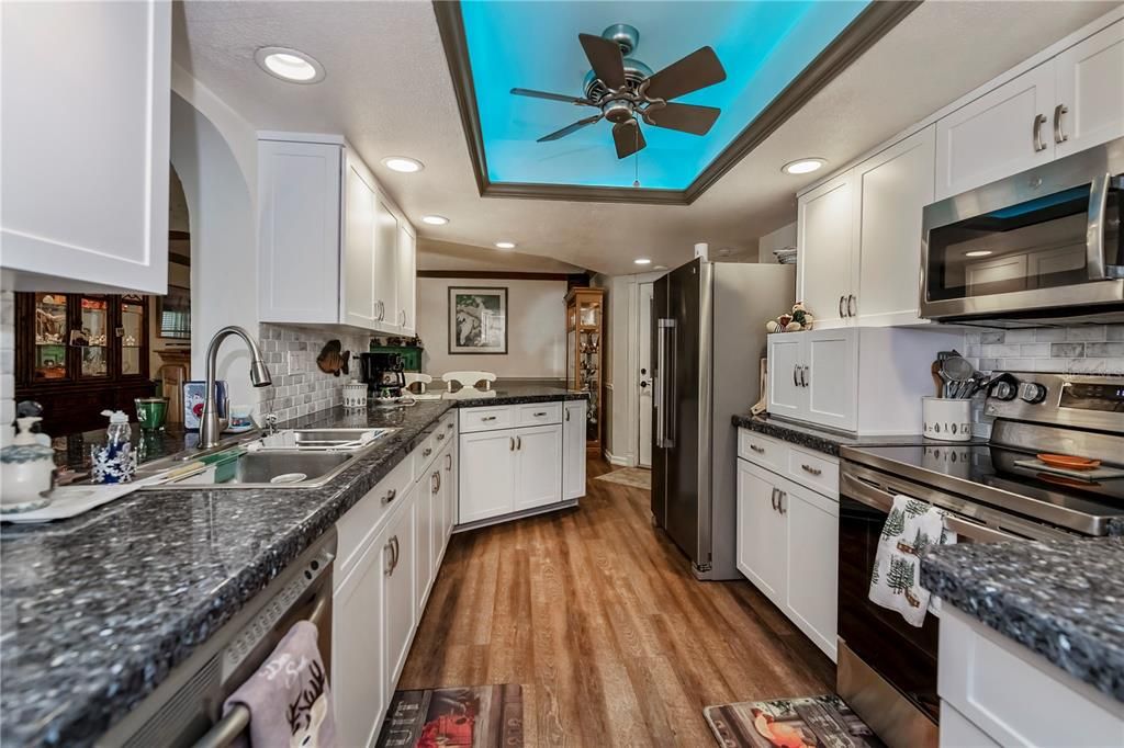 Remodeled, breakfast bar kitchen with granite counters & wood cabinets.