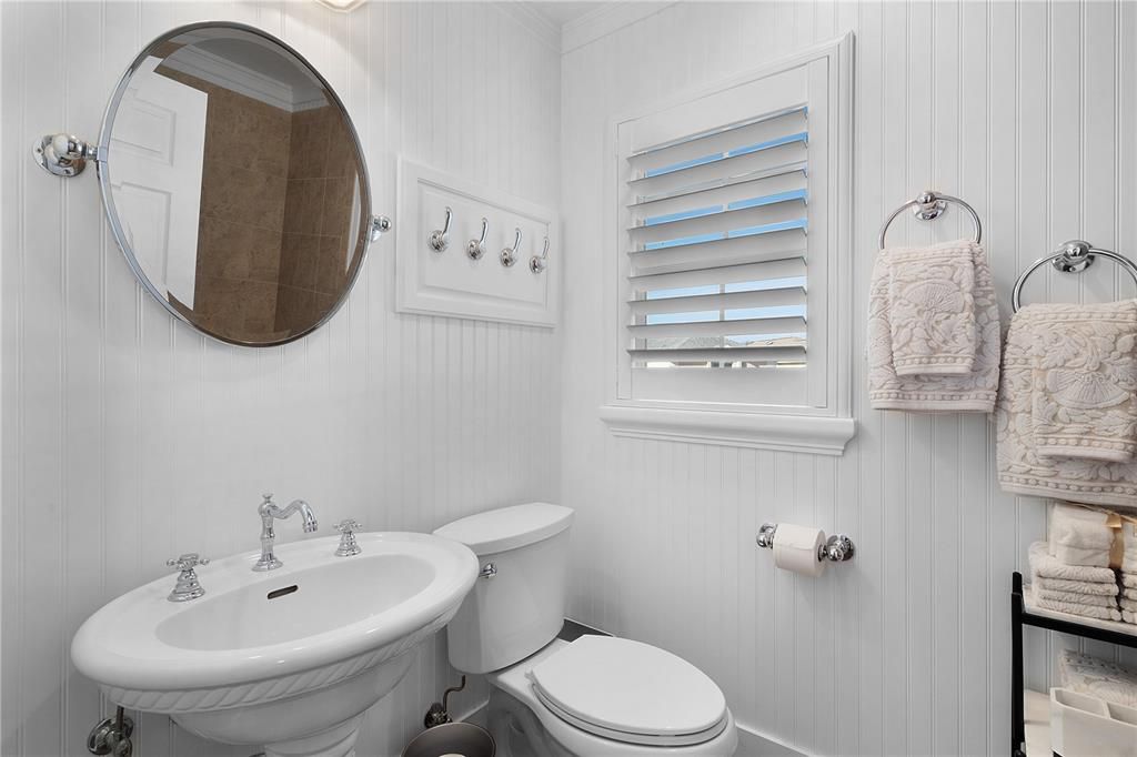 GUEST BATH COMPLETELY REMODELED WITH PEDESTAL SINK, BEADBOARD, AND CUSTOM MIRROR.