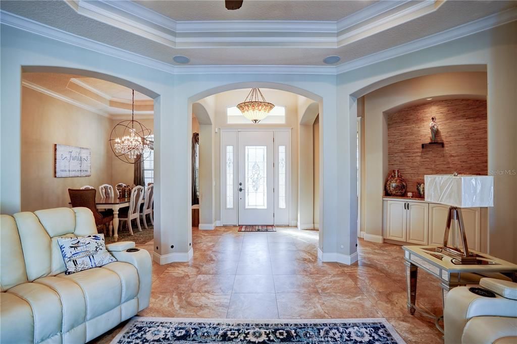 Custom front door leading to the spacious living room overlooking the pool