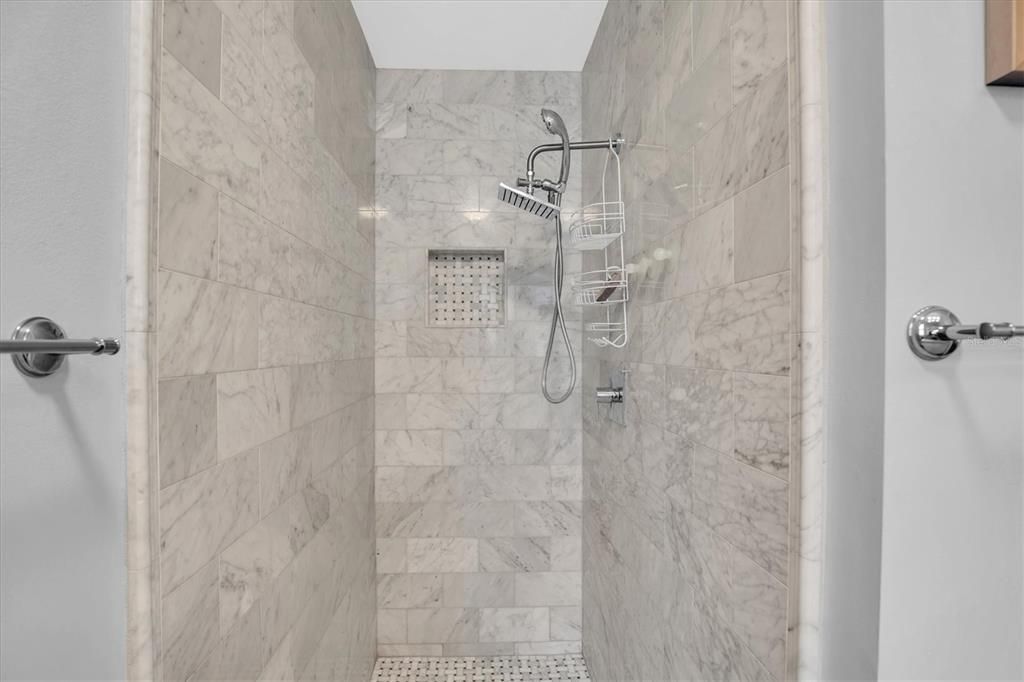 Custom marble walk in shower in primary bedroom suite