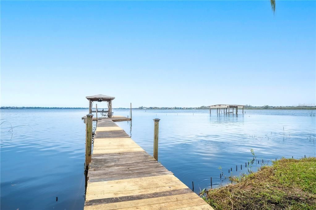 Private boat dock heads out to boat house complete with boat lift