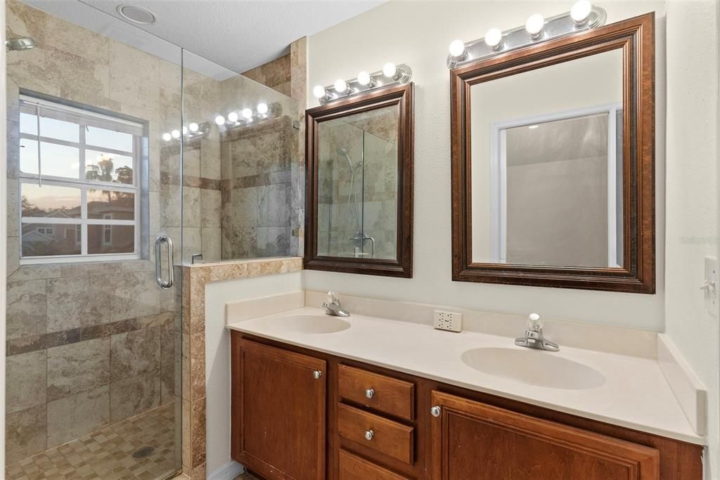 Master bathroom with double vanities and large walk in shower with natural light