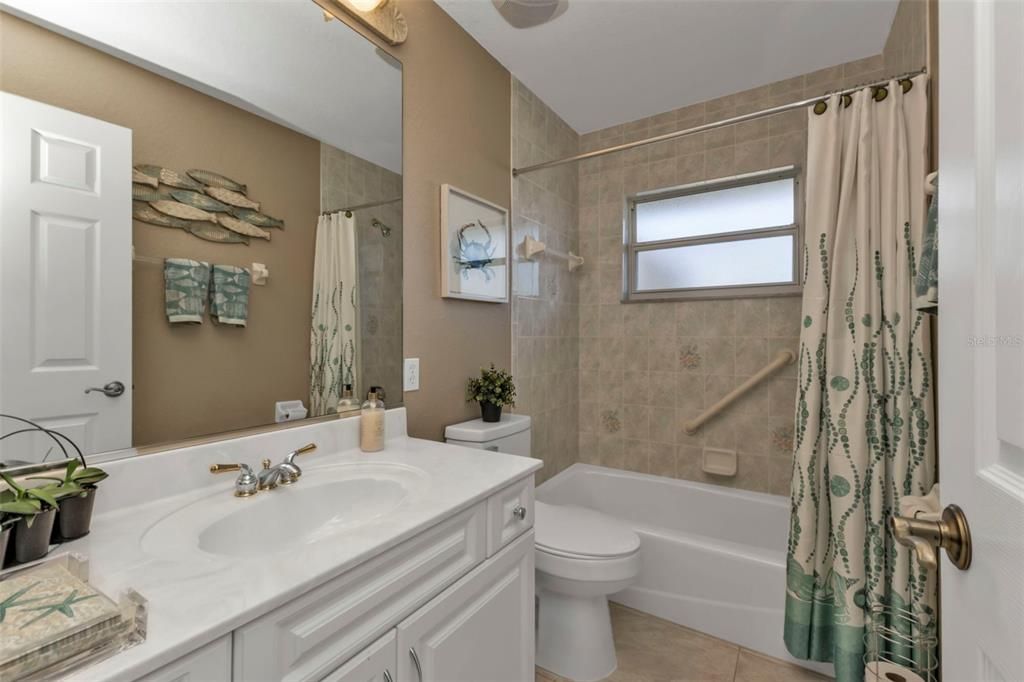 Guest bathroom with single vanity and tub.shower combo.