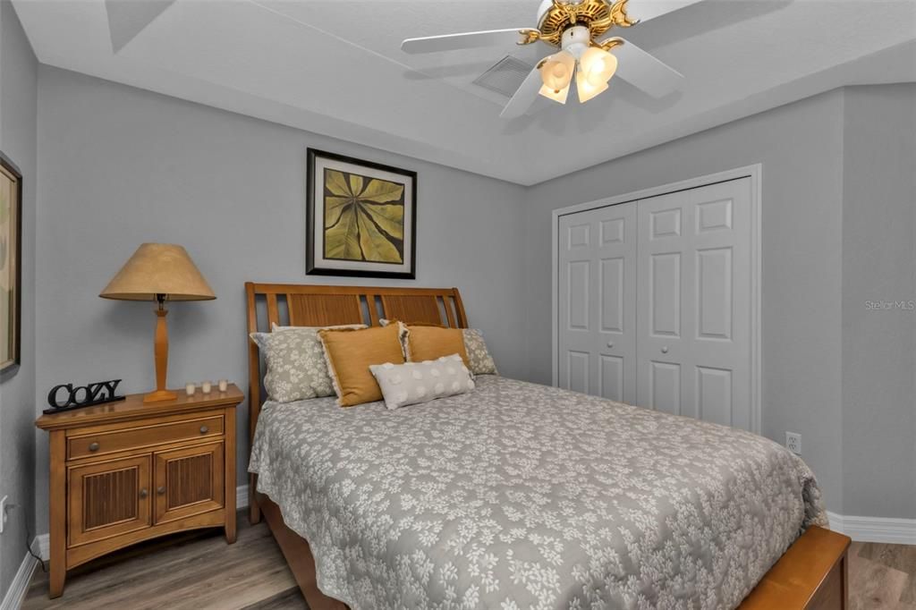 Bedroom 1 with luxury vinyl flooring, tray ceilings, and a large reach in closet.