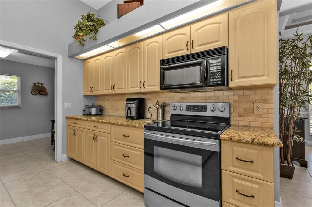 Lovely granite countertops and backsplash finish this kitchen gracefully!