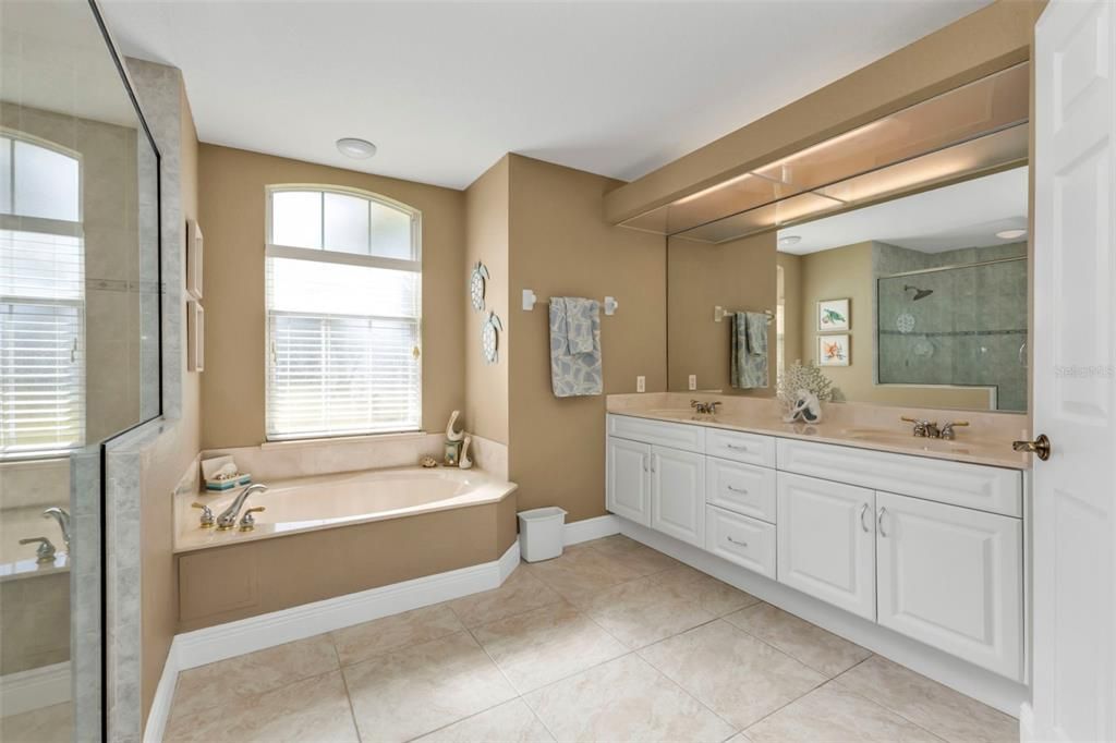 Huge primary en suite bathroom with walk in shower, jacuzzi tub and dual sink vanity.