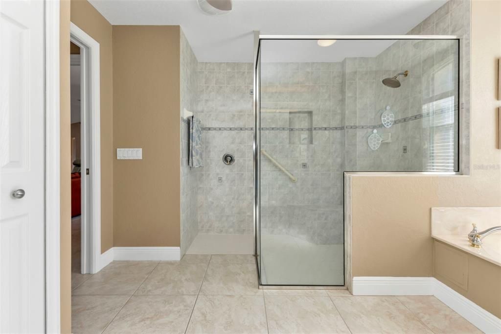 Large walk in shower with glass enclosure.