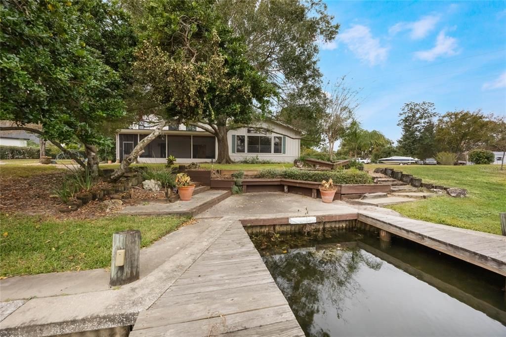 This photo shows the rear elevation of the home from the edge of the dock.