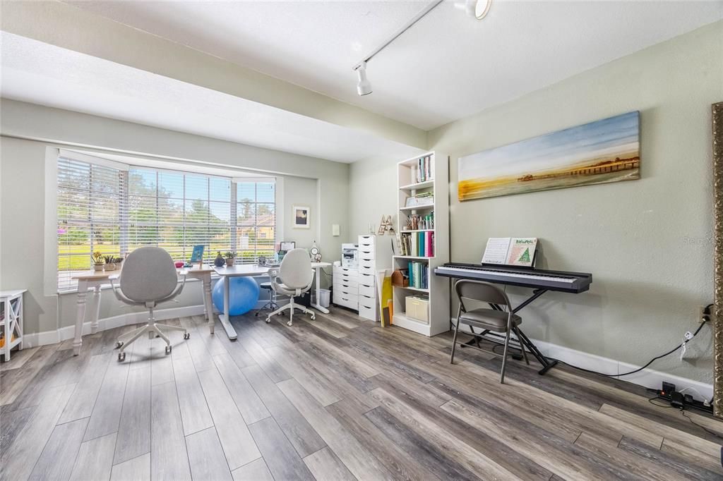 View of the 4th bedroom on the lower level. The photo shows a large bay window to the left.