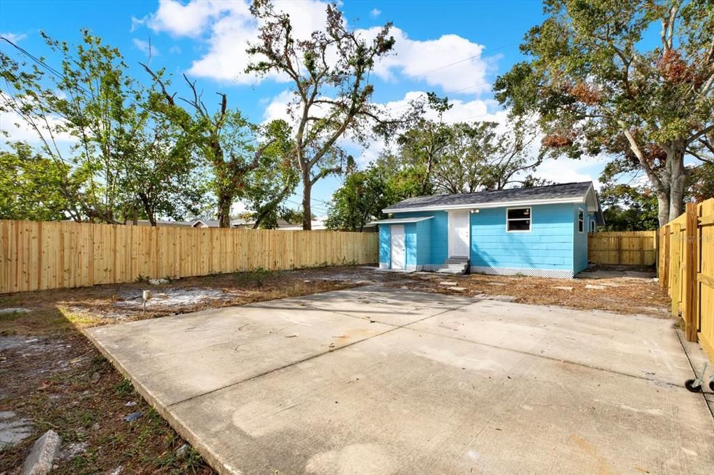 Fenced in backyard with parking pad