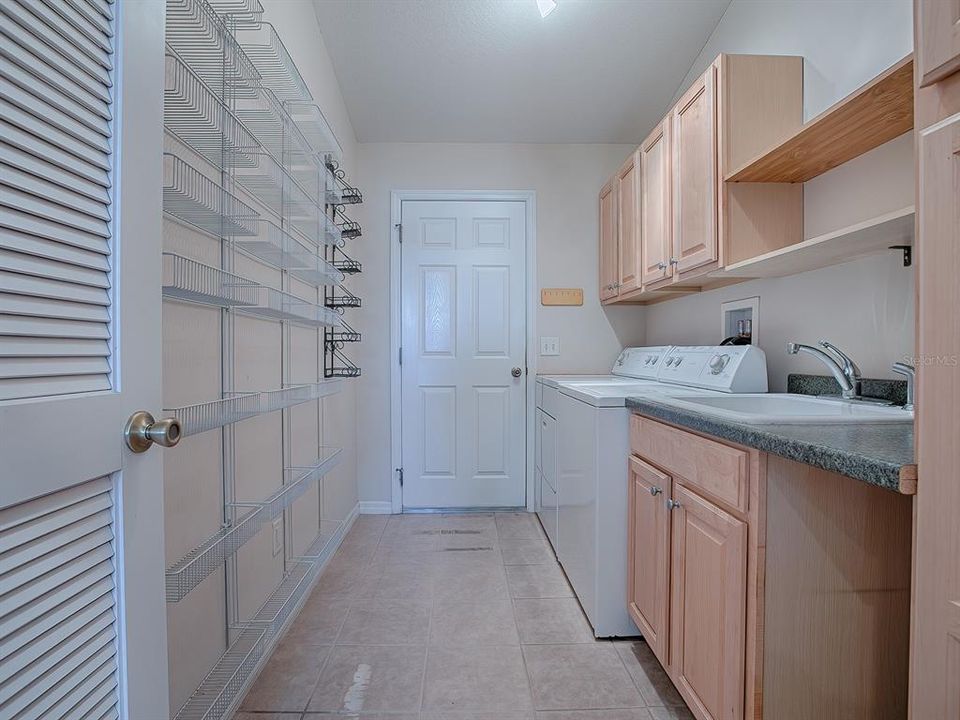 PLENTY OF STORAGE SPACE IN THIS PANTRY/LAUNDRY ROOM! CABINETS, SHELVING AND A SINK